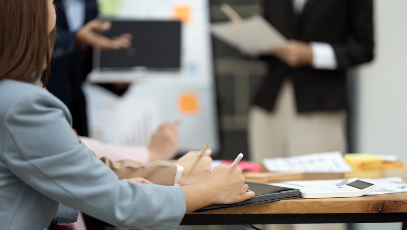 Close-up of business woman writing text on digital tablet during business training